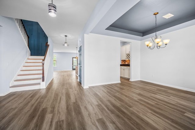 202 Buttercup Ln, Summerville, SC 29486 - unfurnished living room with stairs, dark wood finished floors, a chandelier, and a raised ceiling