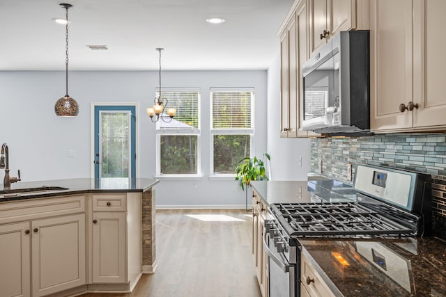 202 Buttercup Ln, Summerville, SC 29486 - kitchen with appliances with stainless steel finishes, decorative backsplash, light wood-style floors, decorative light fixtures, and cream cabinets