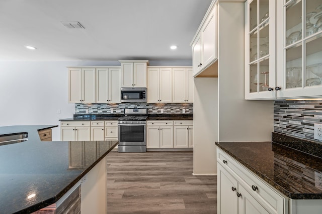 202 Buttercup Ln, Summerville, SC 29486 - kitchen featuring stainless steel appliances, decorative backsplash, wood finished floors, glass insert cabinets, and recessed lighting