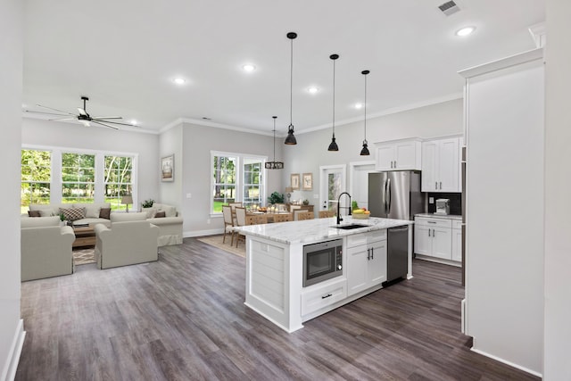 kitchen featuring light stone counters, sink, an island with sink, white cabinets, and stainless steel appliances