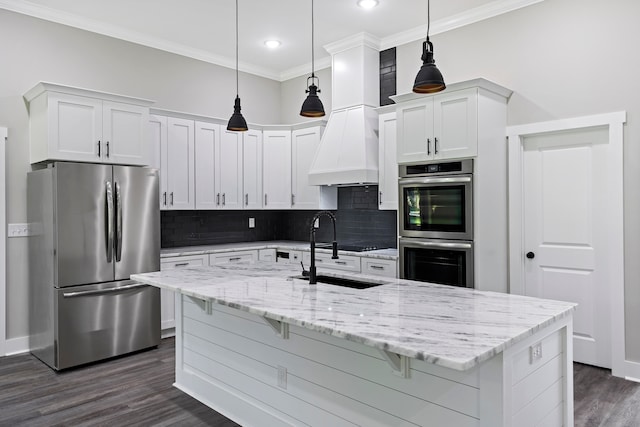 kitchen featuring an island with sink, decorative light fixtures, white cabinetry, stainless steel appliances, and dark hardwood / wood-style floors