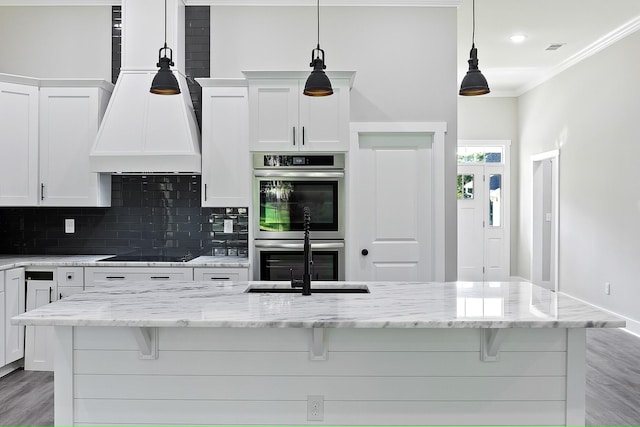 kitchen featuring white cabinets, stainless steel double oven, decorative light fixtures, and black electric stovetop