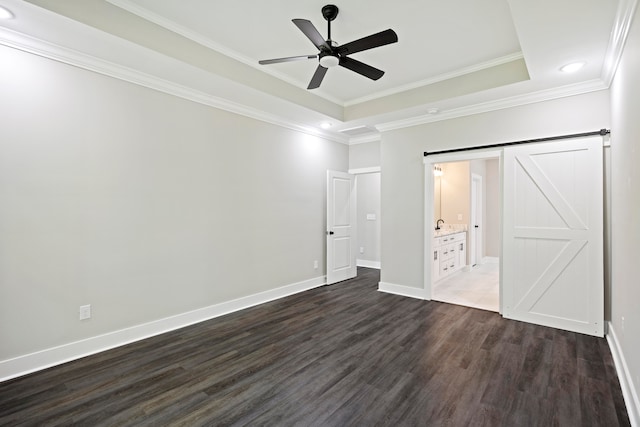 unfurnished bedroom with dark hardwood / wood-style flooring, crown molding, a tray ceiling, ceiling fan, and ensuite bathroom