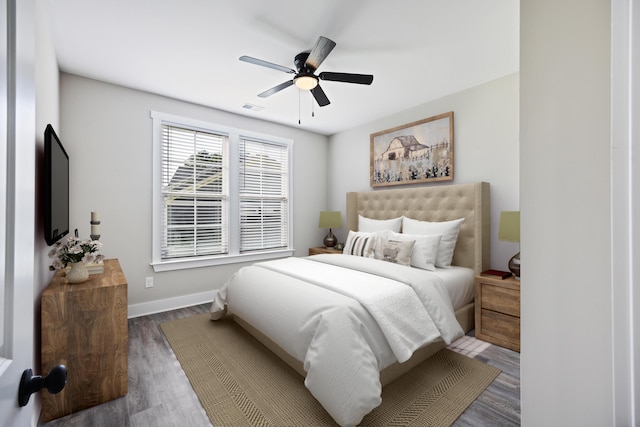 bedroom with dark hardwood / wood-style flooring and ceiling fan