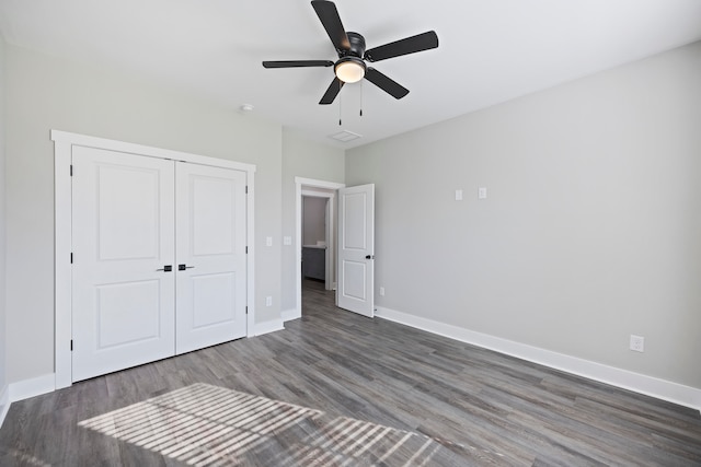 unfurnished bedroom with ceiling fan, a closet, and dark wood-type flooring