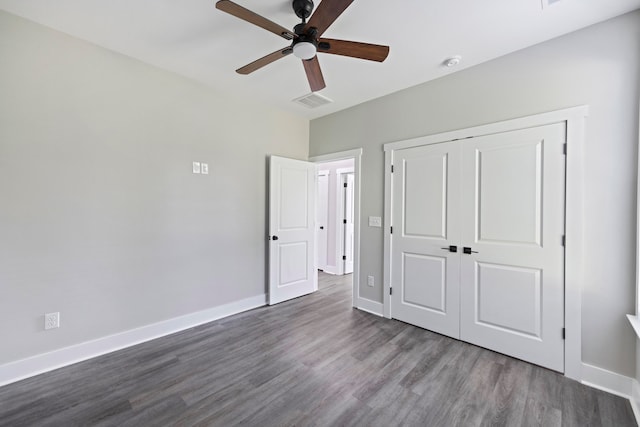 unfurnished bedroom featuring a closet, ceiling fan, and dark hardwood / wood-style flooring