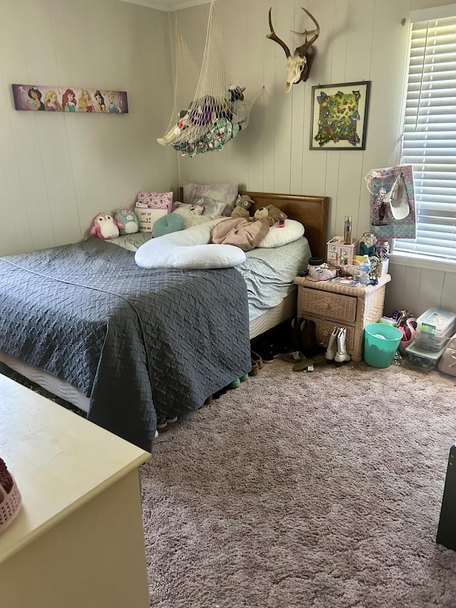 bedroom with a decorative wall and carpet floors