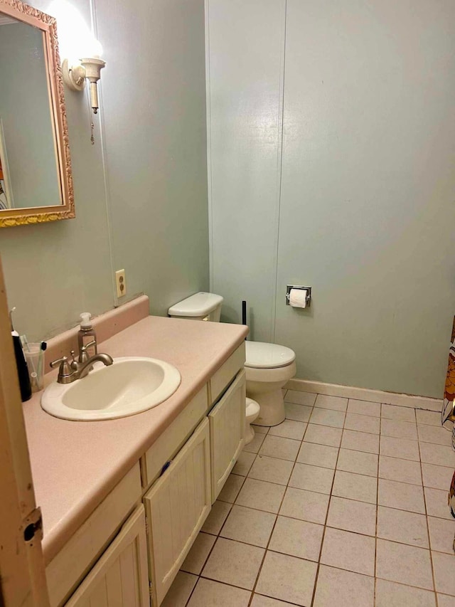 bathroom with toilet, tile patterned flooring, and vanity