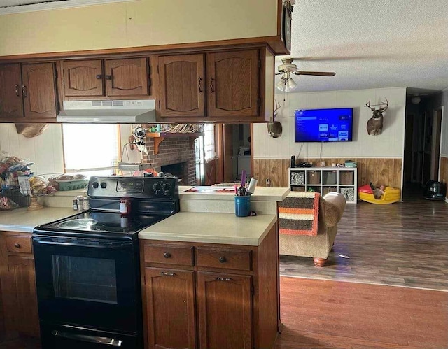 kitchen with black / electric stove, light countertops, a ceiling fan, under cabinet range hood, and wood finished floors