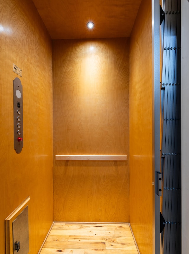 room details with elevator and hardwood / wood-style flooring