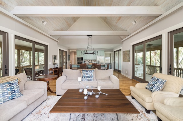 living room featuring vaulted ceiling with beams, light hardwood / wood-style flooring, wooden ceiling, and an inviting chandelier