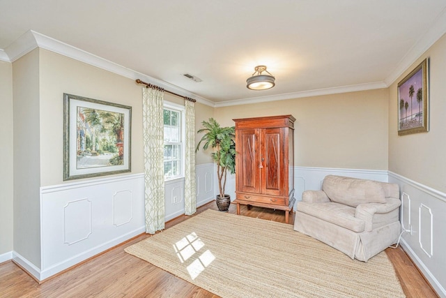 1227 River Rd, Johns Island, SC 29455 - living area with light wood-style floors, crown molding, a wainscoted wall, and a decorative wall