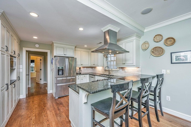 1227 River Rd, Johns Island, SC 29455 - kitchen featuring appliances with stainless steel finishes, a peninsula, a sink, tasteful backsplash, and a kitchen bar