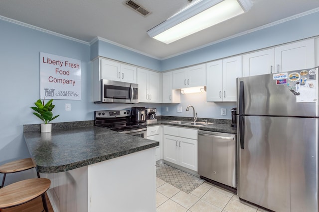 kitchen featuring stainless steel appliances, a peninsula, a sink, visible vents, and white cabinets