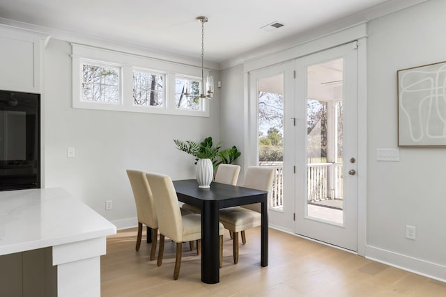 dining room with a wealth of natural light, visible vents, and light wood finished floors