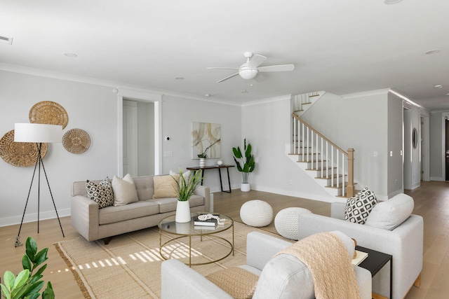 living area featuring baseboards, stairs, ornamental molding, and wood finished floors