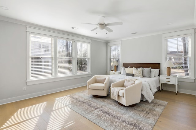 bedroom with baseboards, multiple windows, visible vents, and crown molding