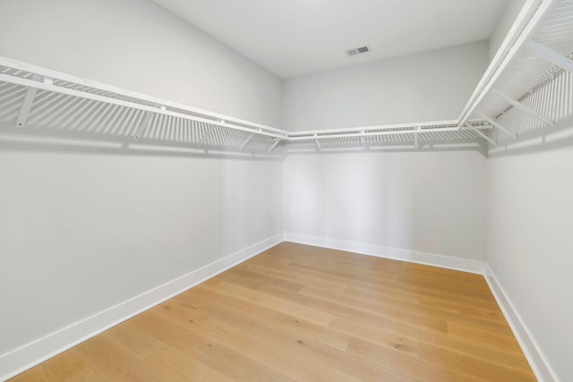 spacious closet featuring wood finished floors and visible vents