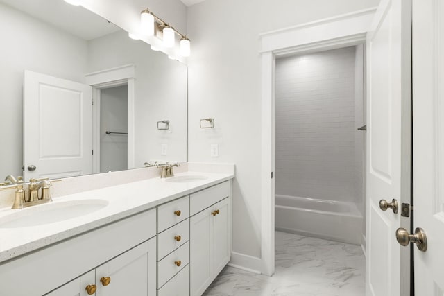 bathroom featuring marble finish floor, a sink, baseboards, and double vanity