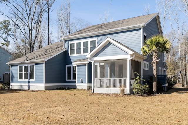 back of house featuring a sunroom and a yard