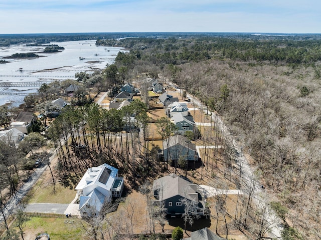 birds eye view of property featuring a water view and a view of trees