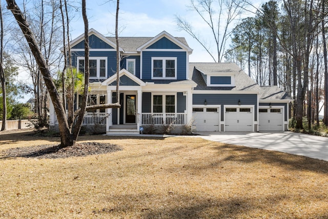 craftsman house with covered porch, a garage, a shingled roof, driveway, and a front lawn