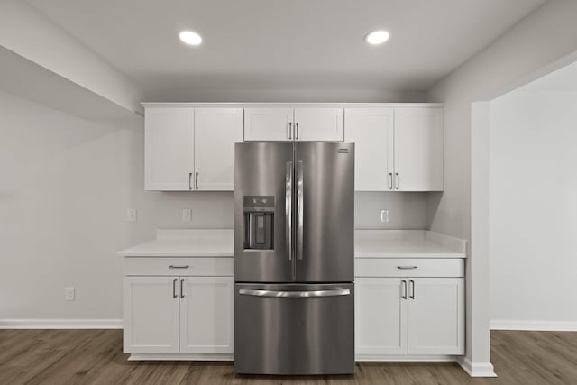 kitchen with stainless steel refrigerator with ice dispenser, white cabinetry, and wood finished floors