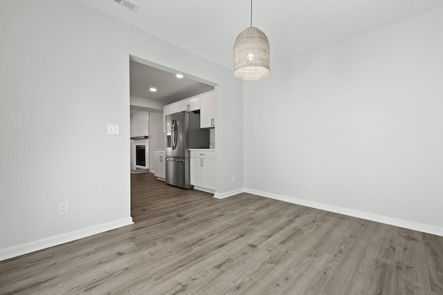 unfurnished dining area featuring recessed lighting, baseboards, visible vents, and wood finished floors