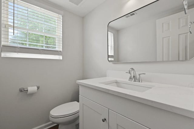 bathroom with visible vents, baseboards, toilet, and vanity