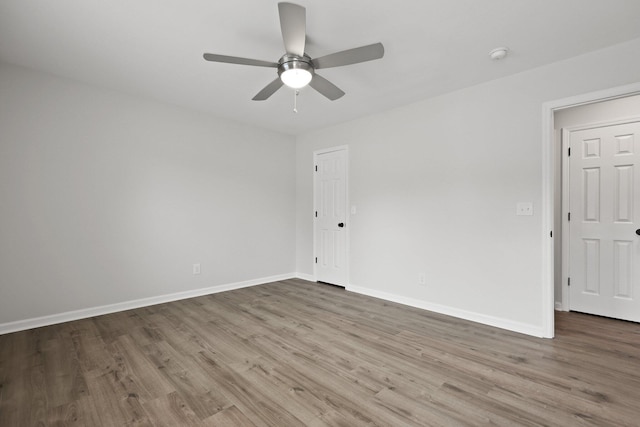 unfurnished room featuring baseboards, a ceiling fan, and wood finished floors