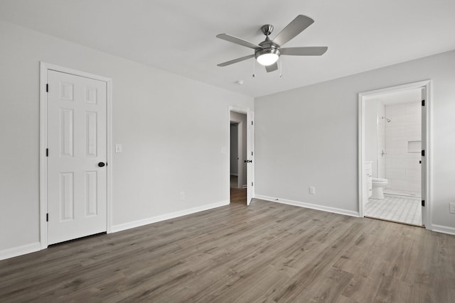 unfurnished bedroom featuring baseboards, ceiling fan, wood finished floors, and connected bathroom