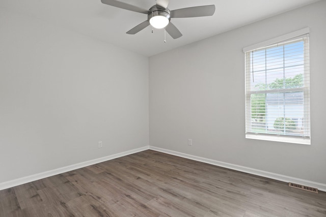 spare room featuring baseboards, visible vents, a wealth of natural light, and wood finished floors