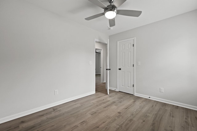 unfurnished bedroom with a ceiling fan, baseboards, and wood finished floors