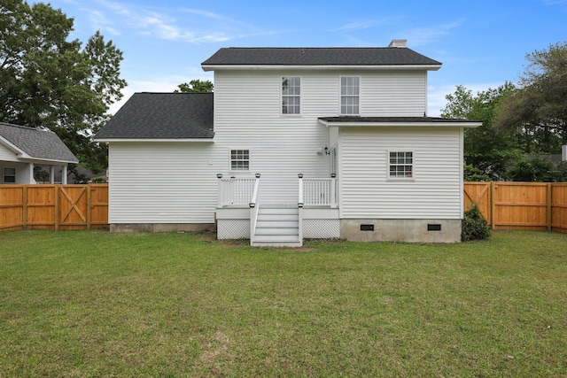 rear view of property featuring a fenced backyard, a lawn, a deck, and crawl space