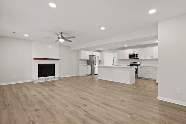 unfurnished living room with baseboards, a ceiling fan, and recessed lighting