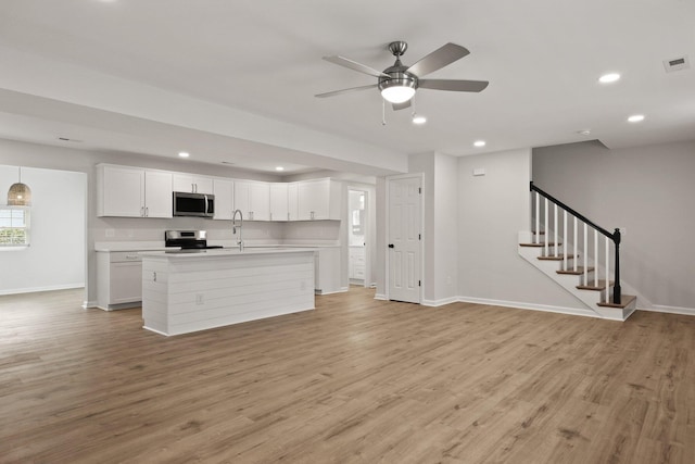 unfurnished living room with visible vents, baseboards, ceiling fan, recessed lighting, and light wood-type flooring