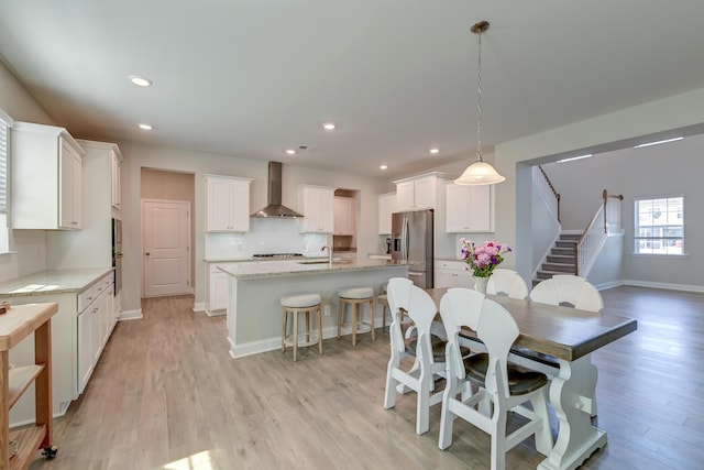 dining space with baseboards, stairway, light wood-style flooring, and recessed lighting