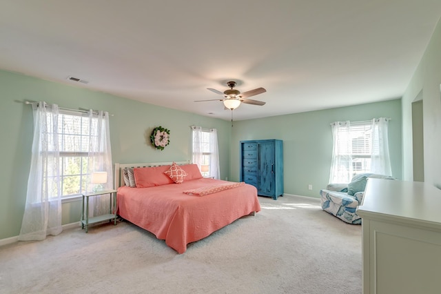 bedroom featuring light colored carpet, visible vents, and multiple windows