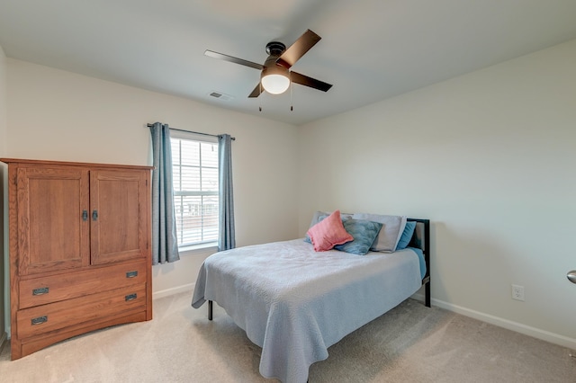 bedroom featuring baseboards, a ceiling fan, visible vents, and light colored carpet