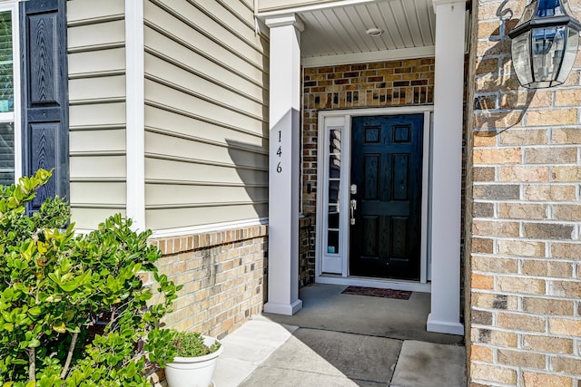 doorway to property with brick siding