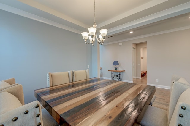 dining area featuring a chandelier, baseboards, and wood finished floors