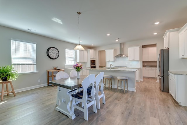 dining space featuring light wood-type flooring, visible vents, baseboards, and recessed lighting