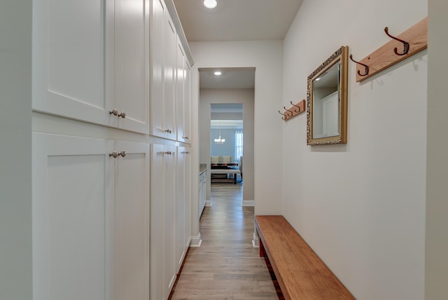 hall featuring light wood finished floors and recessed lighting