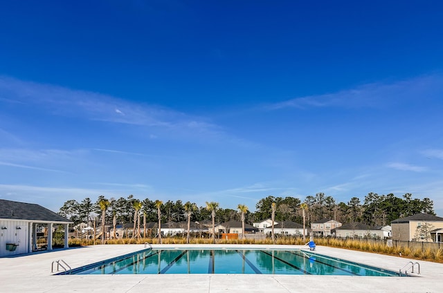 community pool featuring fence and a residential view