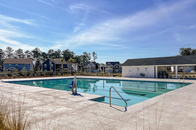 community pool featuring a residential view and a patio