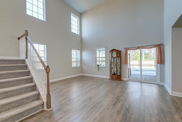 unfurnished living room featuring a wealth of natural light and wood finished floors