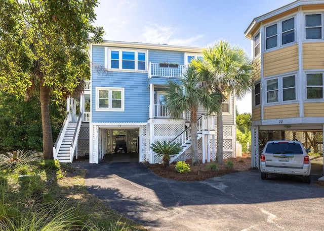 coastal home with driveway, stairway, and a carport