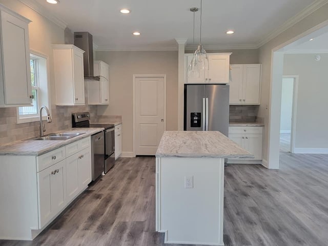 kitchen with stainless steel appliances, wood-type flooring, wall chimney exhaust hood, sink, and a kitchen island