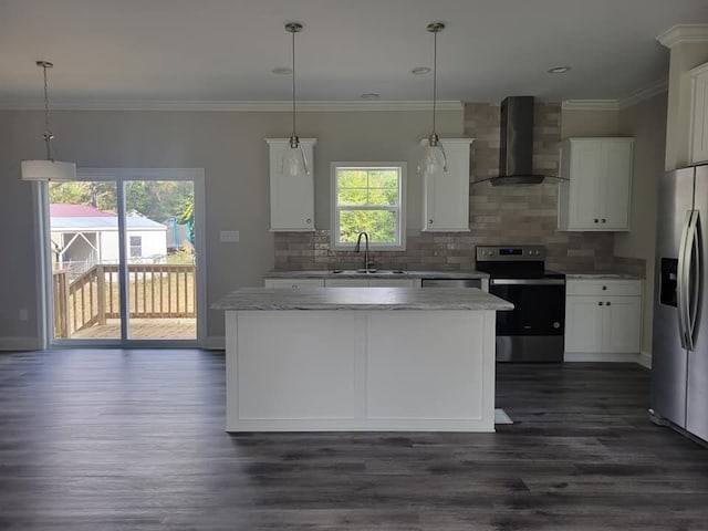 kitchen with hanging light fixtures, wall chimney exhaust hood, white cabinetry, and appliances with stainless steel finishes