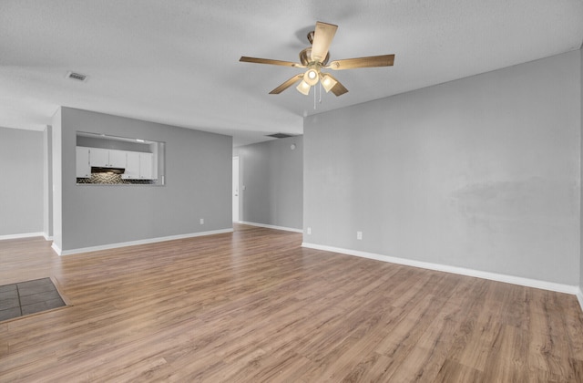 unfurnished living room with ceiling fan and light wood-type flooring